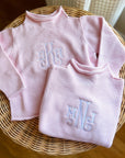 Pink cotton rollneck sweater for kids folded with monogrammed embroidery