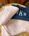 Pink cotton rollneck sweater for kids folded with personalized embroidery