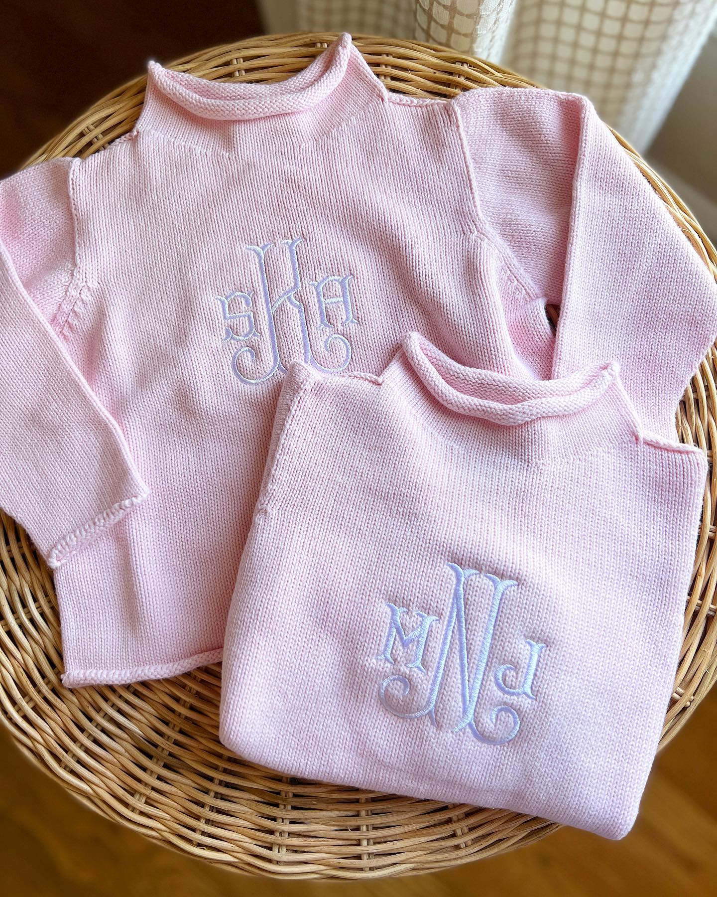 Pink cotton rollneck sweater for kids folded with monogrammed embroidery