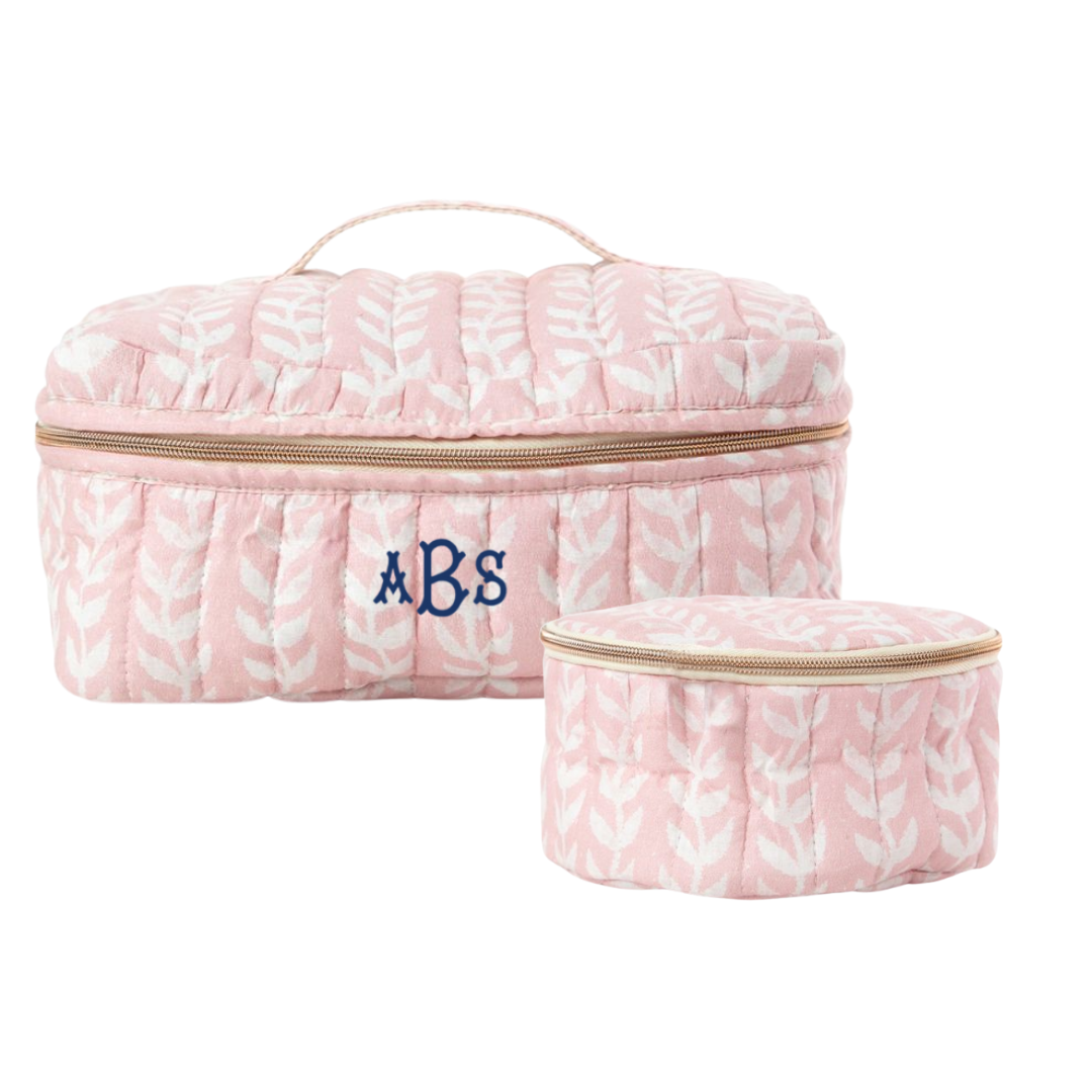 Pink block print-patterned cosmetic bag with monogram on a white background