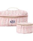 Pink block print-patterned cosmetic bag with monogram on a white background