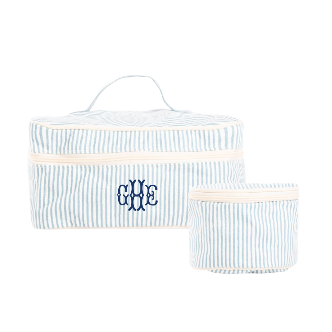 Set of two blue and white striped travel bags with embroidered monogram on a white background