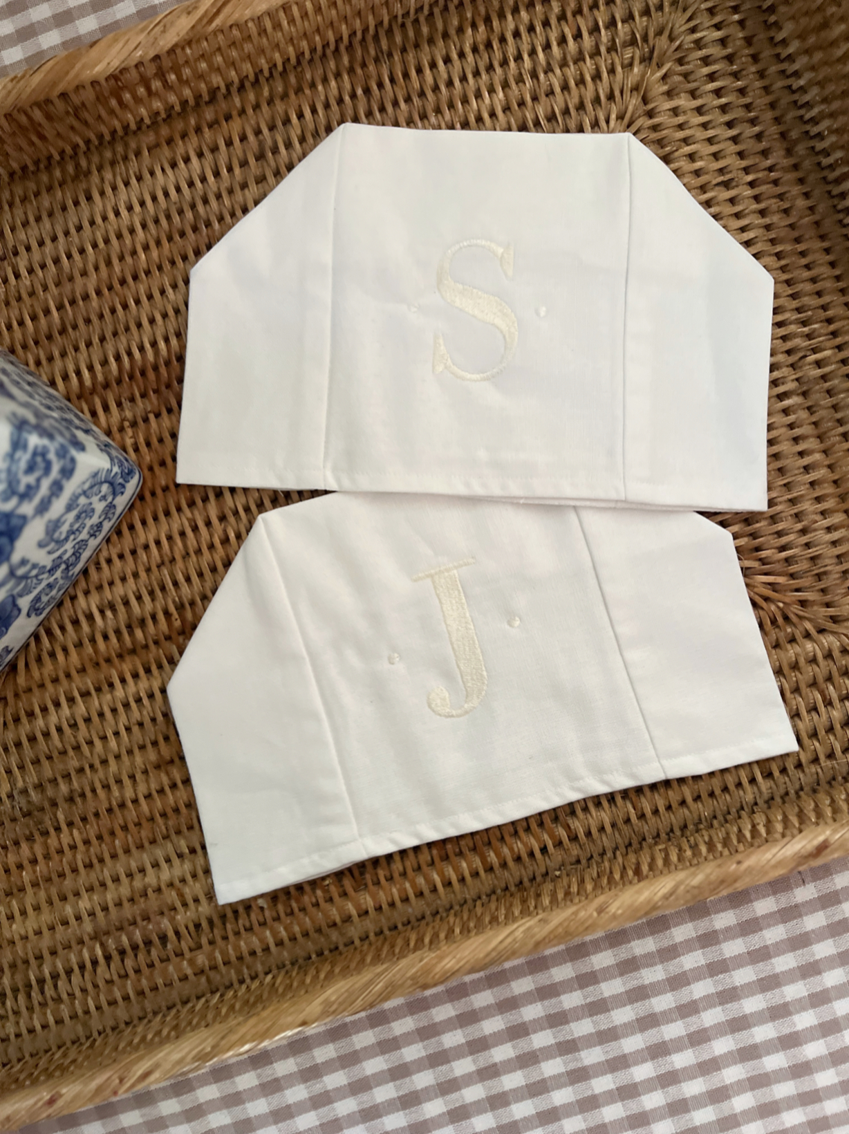 two white linen tissue box covers with embroidered initials