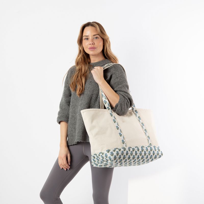 Woman holding a tote bag with floral pattern on a white background