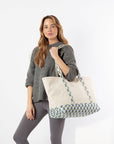 Woman holding a tote bag with floral pattern on a white background