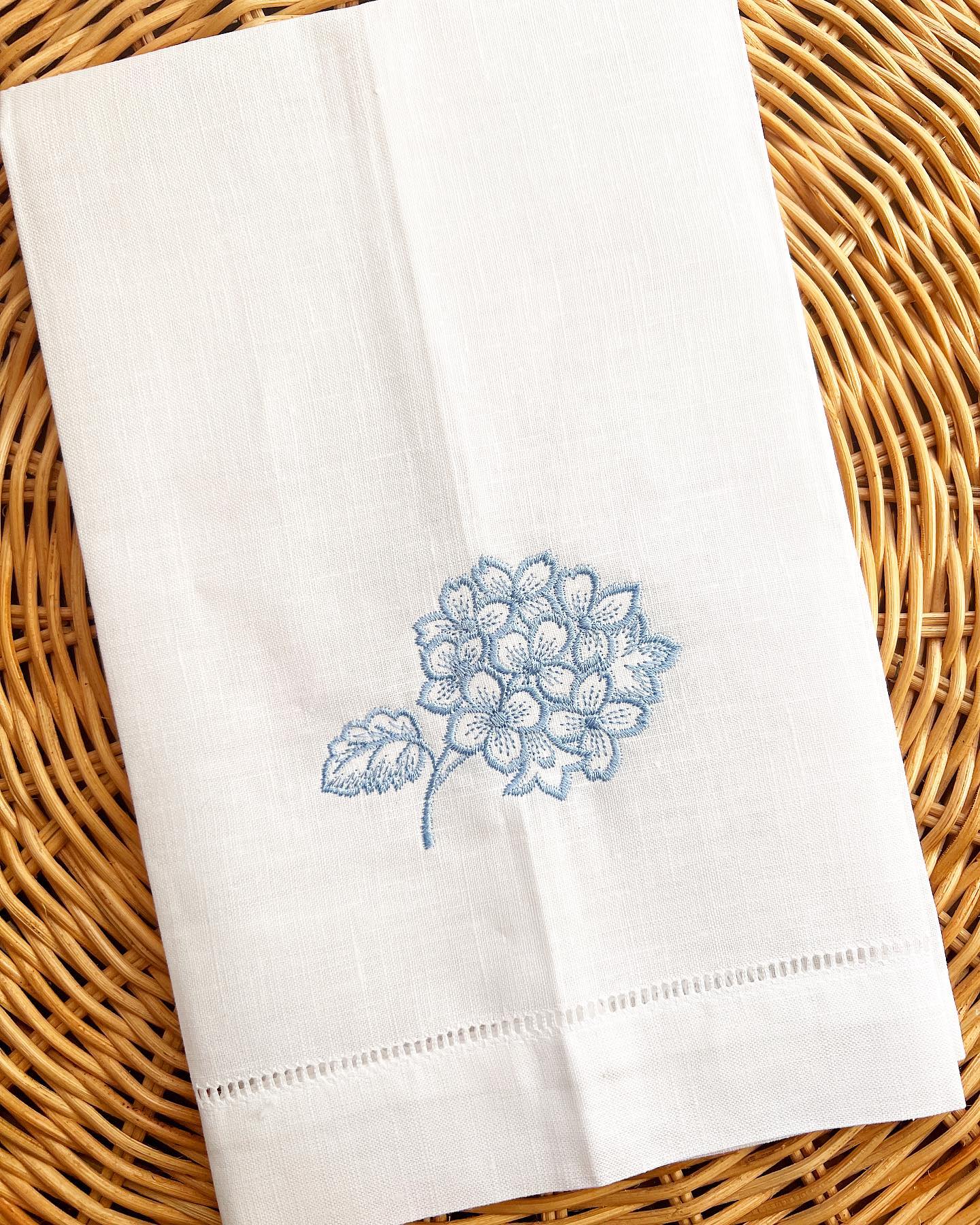 white linen guest towel with embroidered blue hydrangea motif