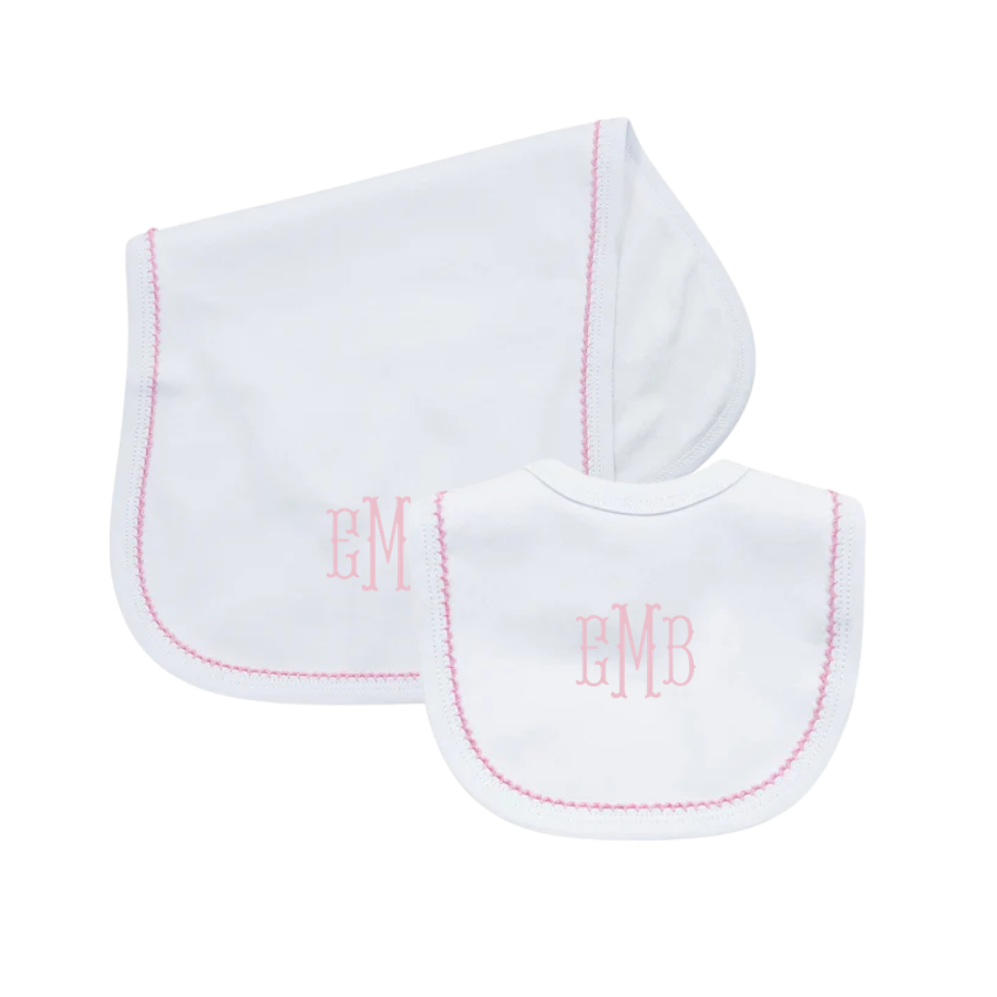 Two white baby bibs with pink monogram on a white background
