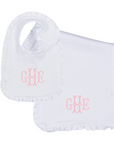 white ruffle bip and burp cloth set with pink embroidered monogram on white background
