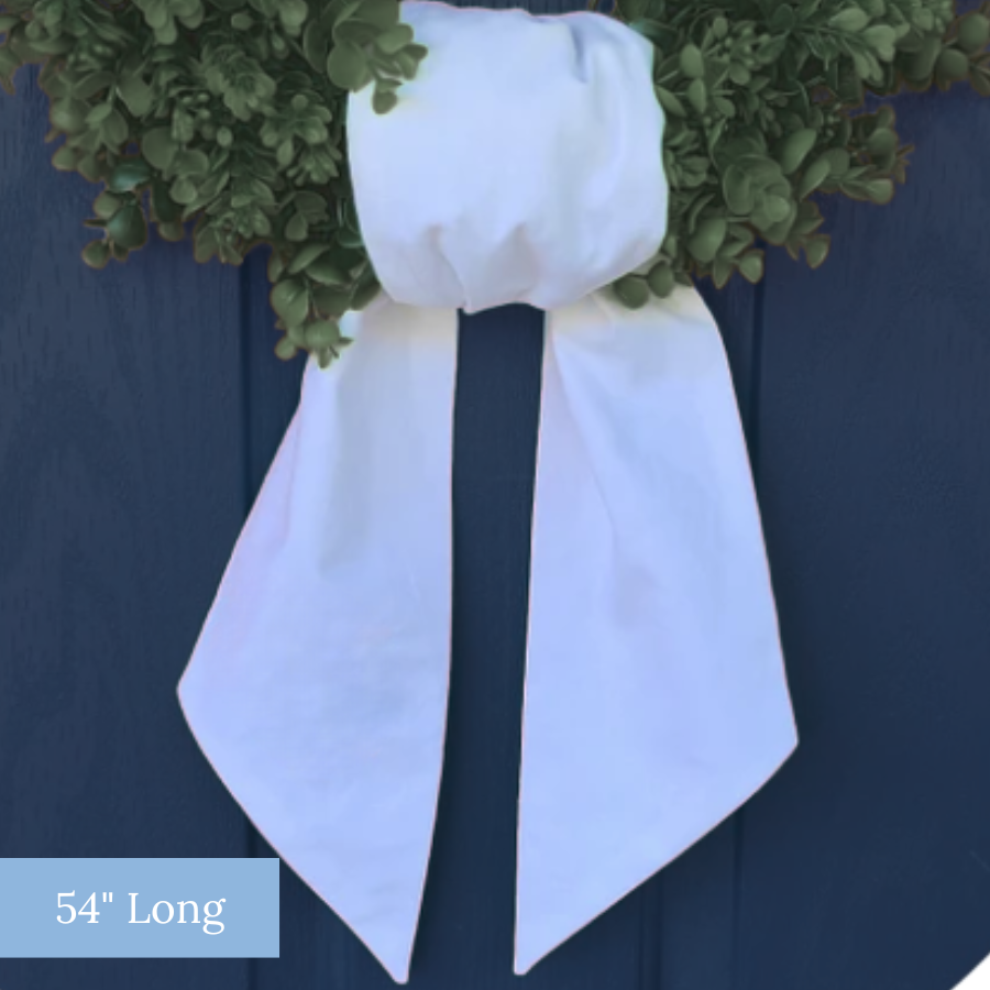 white linen wreath sash tied on a boxwood wreath
