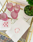 White hemstitch tea towel with pink and red floral initial embroidery styled on kitchen counter